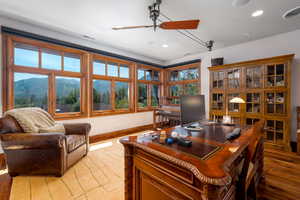 Office area with a mountain view, wood-type flooring, and ceiling fan