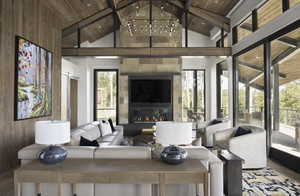 Living area featuring a large fireplace, wooden ceiling, beam ceiling, and plenty of natural light