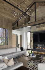 Living room with a high ceiling, a barn door, wooden ceiling, and a glass covered fireplace