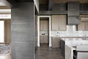 Kitchen with black electric cooktop, decorative backsplash, light countertops, and dark wood-style flooring