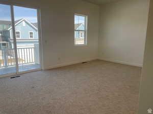 Carpeted spare room with baseboards and visible vents