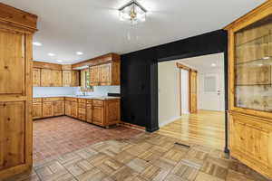 Kitchen with a barn door, baseboards, visible vents, light countertops, and a sink