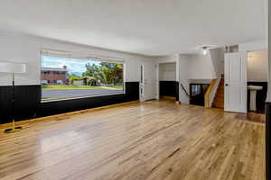 Interior space with stairway, wainscoting, and light wood-style flooring