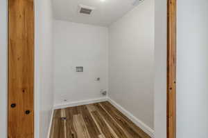 Laundry room with washer hookup, wood finished floors, visible vents, baseboards, and electric dryer hookup