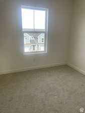 Carpeted empty room with baseboards