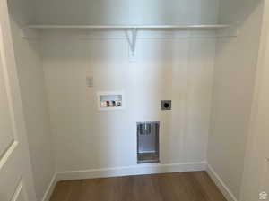 Washroom with washer hookup, hookup for an electric dryer, wood finished floors, laundry area, and baseboards