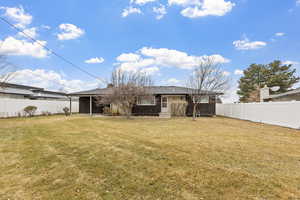 Rear view of house featuring a yard and a fenced backyard and covered patio