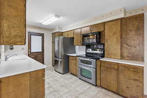 Kitchen with outside entrance to patio and SS Appliances and Solid Surface Counters