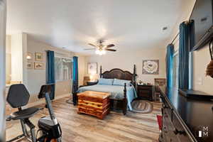 Bedroom featuring visible vents, a ceiling fan, light wood-style flooring, and baseboards