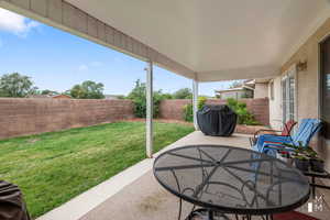 View of patio with outdoor dining space, area for grilling, and a fenced backyard