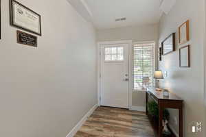 Entryway featuring wood finished floors, visible vents, and baseboards