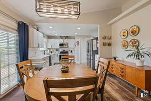 Dining space with a chandelier, dark wood-style flooring, and recessed lighting