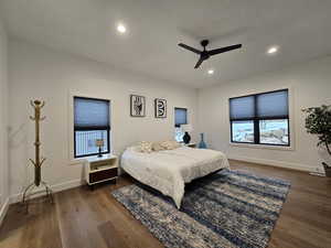 Master bedroom featuring dark wood-style floors, baseboards, a ceiling fan, and recessed lighting