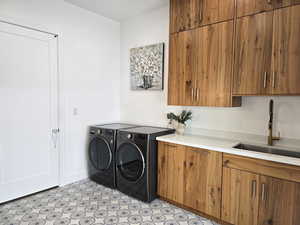 Laundry room with washing machine and dryer, a sink, cabinet space, and beautiful tiled floor