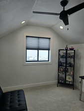 Bedroom with vaulted ceiling, a textured ceiling, light carpet, and baseboards