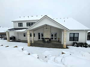 View of the back of the home with a covered porch, fireplace, french doors, and a separate door into the mudroom.