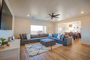 Living room featuring ceiling fan, light wood-style flooring, and recessed lighting