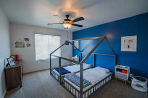 Carpeted bedroom featuring ceiling fan, visible vents, and baseboards