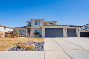 Prairie-style home with stucco siding, concrete driveway, an attached garage, fence, and a front lawn