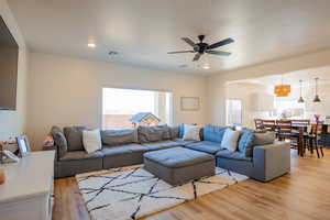 Living area with light wood-type flooring, visible vents, and recessed lighting