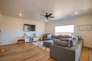 Living area with baseboards, visible vents, a ceiling fan, light wood-type flooring, and recessed lighting