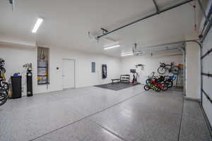 Garage featuring strapped water heater and electric panel