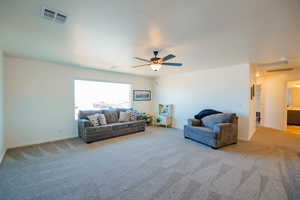 Living area featuring baseboards, visible vents, and light colored carpet