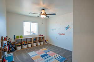 Game room with carpet floors, baseboards, and a ceiling fan