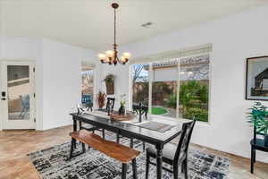 Dining area with an inviting chandelier, baseboards, and visible vents