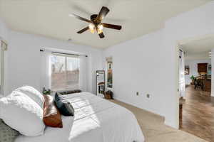 Bedroom with baseboards, a ceiling fan, visible vents, and light colored carpet