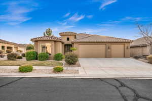 Mediterranean / spanish-style home with a garage, driveway, a tile roof, and stucco siding