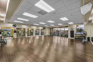 Exercise room with a paneled ceiling and wood finished floors