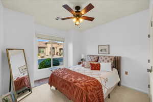 Bedroom with light carpet, a ceiling fan, visible vents, and baseboards