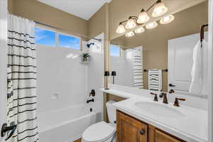 Full bath with shower / bath combination with curtain, vanity, and toilet