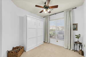 Bedroom with a closet, light colored carpet, visible vents, a ceiling fan, and baseboards