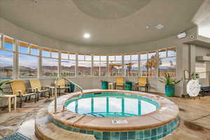 View of pool featuring an indoor hot tub and a mountain view