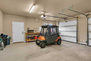 Garage featuring a garage door opener and baseboards