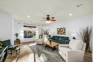 Living room with recessed lighting, visible vents, ceiling fan, and light tile patterned floors