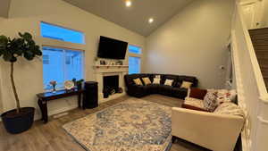 Living room featuring high vaulted ceiling and light hardwood / wood-style flooring