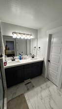 Bathroom featuring vanity and a textured ceiling