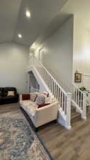 Living room with hardwood / wood-style flooring and high vaulted ceiling