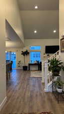 Hallway with a high ceiling and dark hardwood / wood-style flooring