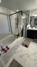 Bathroom with independent shower and bath, vanity, and a textured ceiling