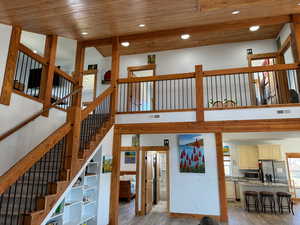 Staircase with wooden ceiling, visible vents, and wood finished floors