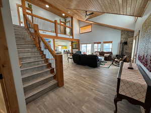 Living room with recessed lighting, a gas stove, wood finished floors, wooden ceiling, and stairs