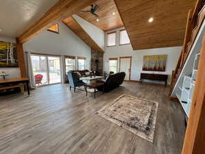 Living area featuring ceiling fan, high vaulted ceiling, wooden ceiling, and wood finished floors