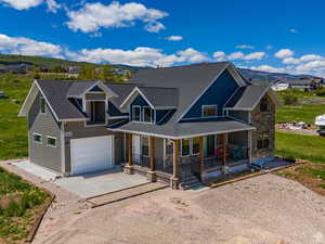 View of front facade featuring a garage, a mountain view, a porch, and concrete driveway