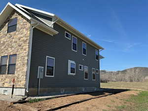 View of side of property with  stone siding, and a mountain view