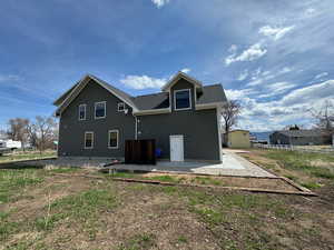 Rear view of house with a shingled roof, a patio area, and fence