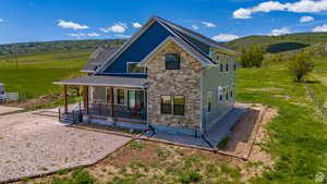 Exterior space featuring covered porch, stone siding, and a mountain view